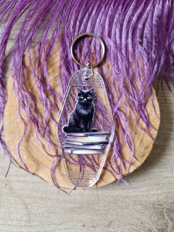 Porte-clés motel à paillettes chat noir qui lit,