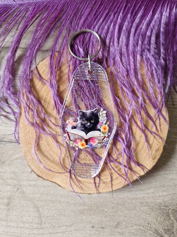 Porte-clés motel à paillettes chat noir qui lit,