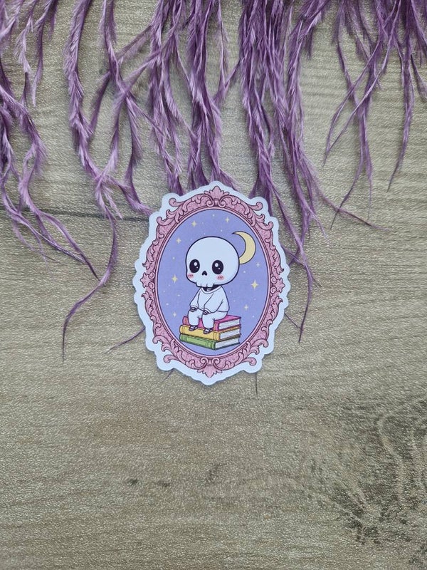 Sticker squelette sur pile de livres,