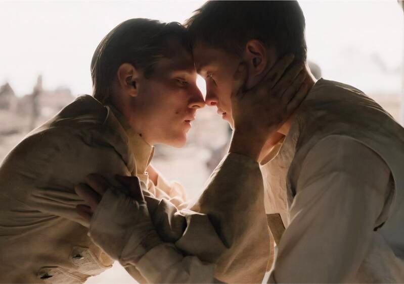 Een scène uit Coward, de nieuwste film van de Belgische regisseur Lukas Dhont met de 2 hoofrolspelers Emmanuel Macchia als Pierre (rechts) en Valentin Campagne als Francis (links).  Je ziet de 2 mannen in een liefdevolle omhelzing