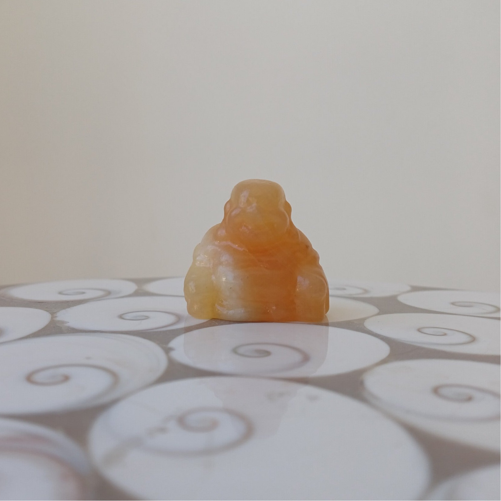 Oranje calciet carving (lachende Boeddha)