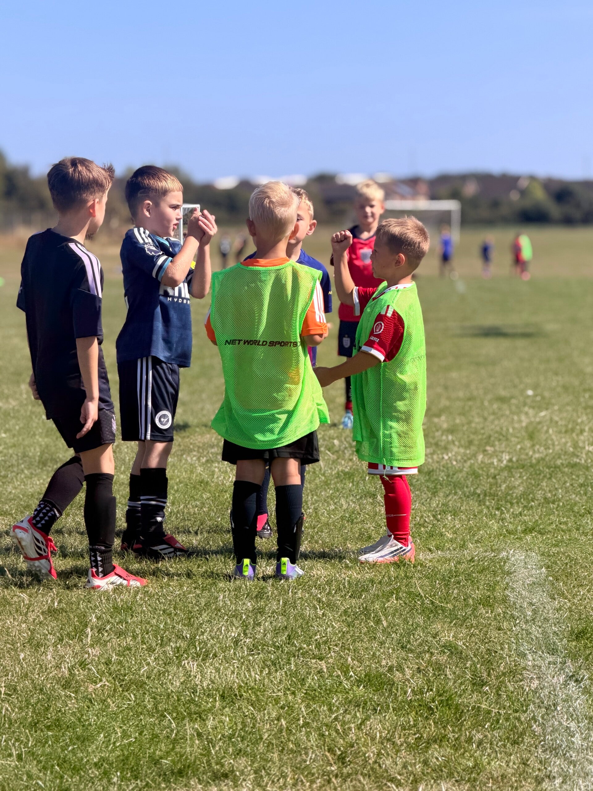 "Group of children lined up in bibs at a DJR half term football camp"