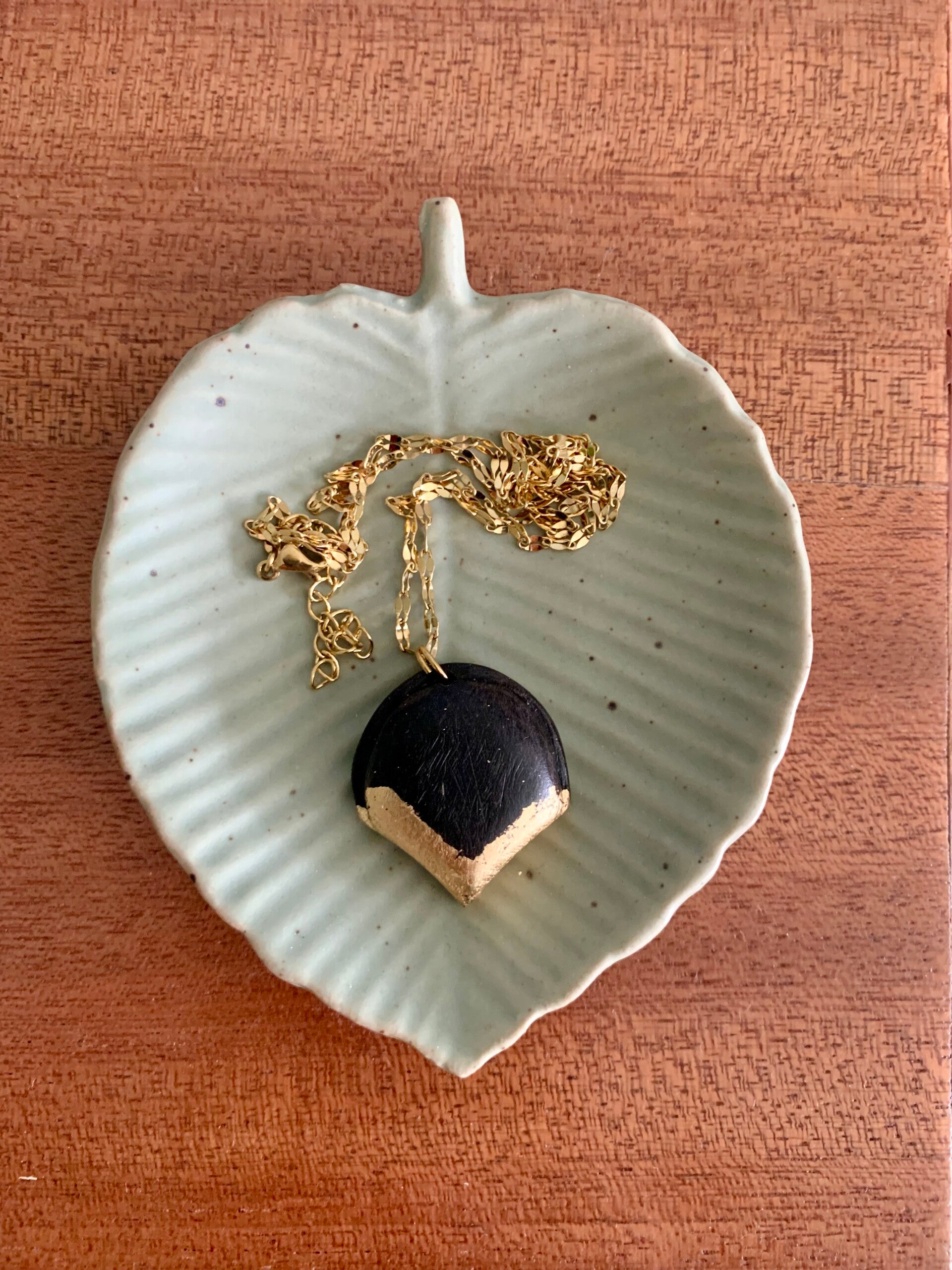 Collier doré avec pendentif en ébène et feuille d'or