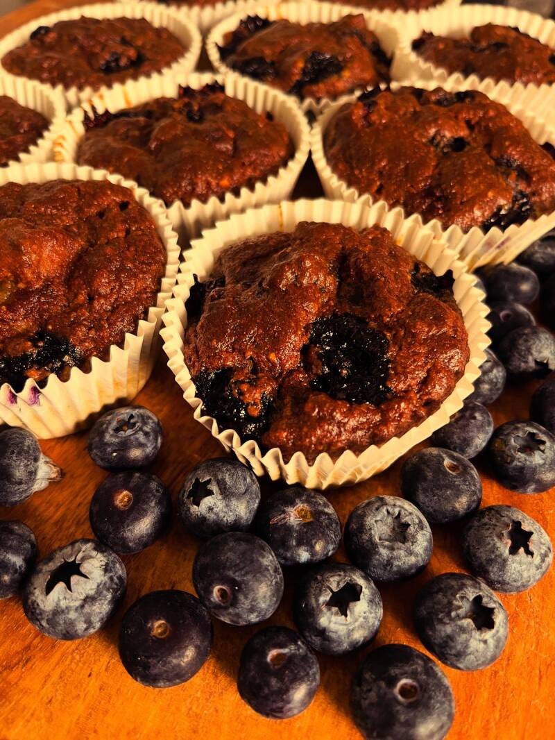 Er liggen blauwe bessen muffins op een houten serveerplank