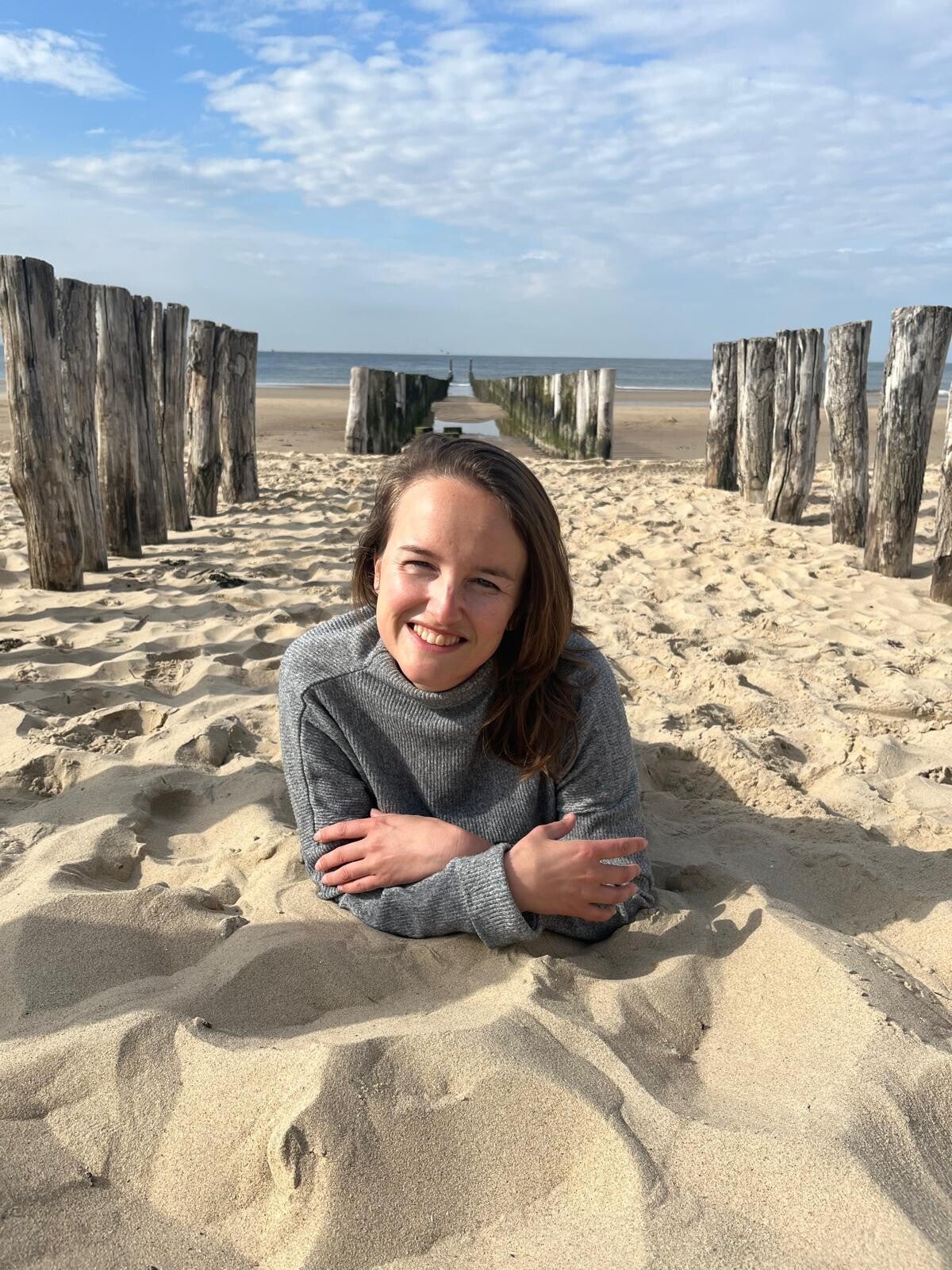 Vrouw ligt op strand en lacht