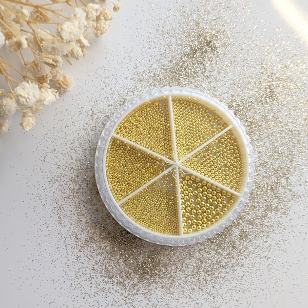 Bakje met goudkleurige kralen