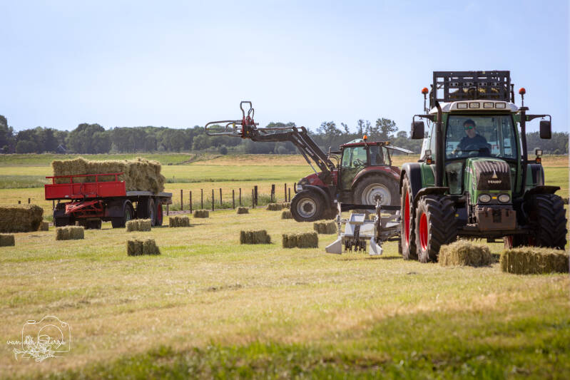 Loonbedrijf aan het werk tijdens het persen van hooi