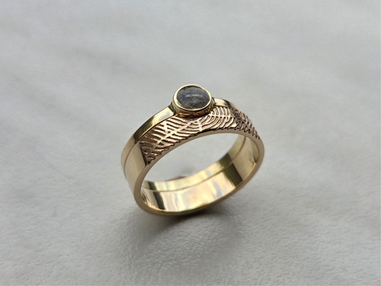 Geelgouden ring met vingerafdruk en as in een apart bakje.