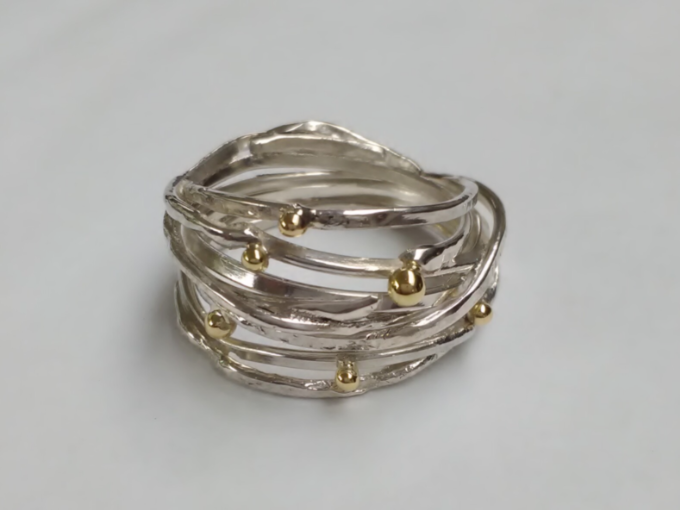 Een wikkelring gemaakt van eigen zilver en geelgoud.