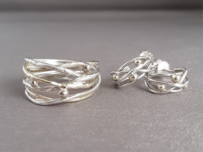 Een wikkelring met bijpassende oorbellen gemaakt van eigen zilver en geelgoud.