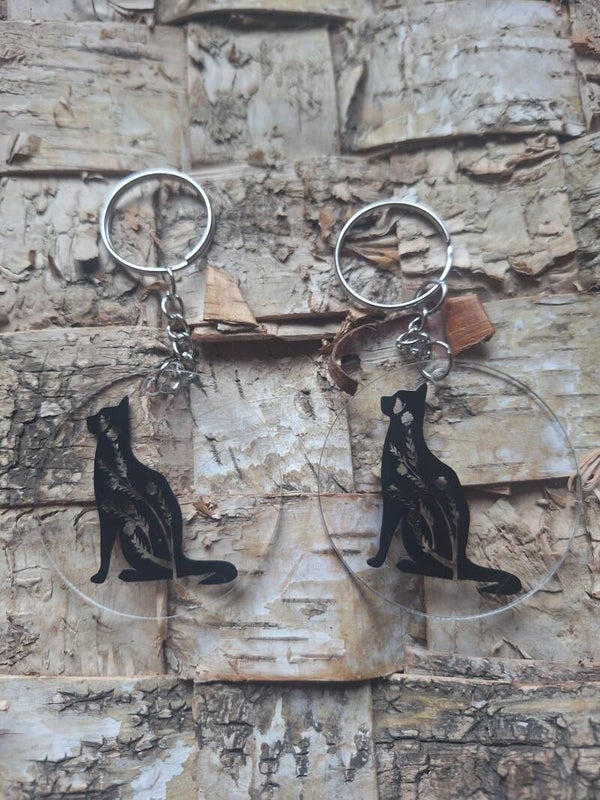 Der Schlüsselanhänger ist aus Acryl und wird mit einem Katzenmotiv verziert. schwarz, Katze, Taschenanhänger, Geschenkidee