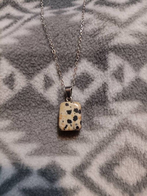 This is a polished pendant made of dalmatian stone, also widely known as dalmatian jasper.