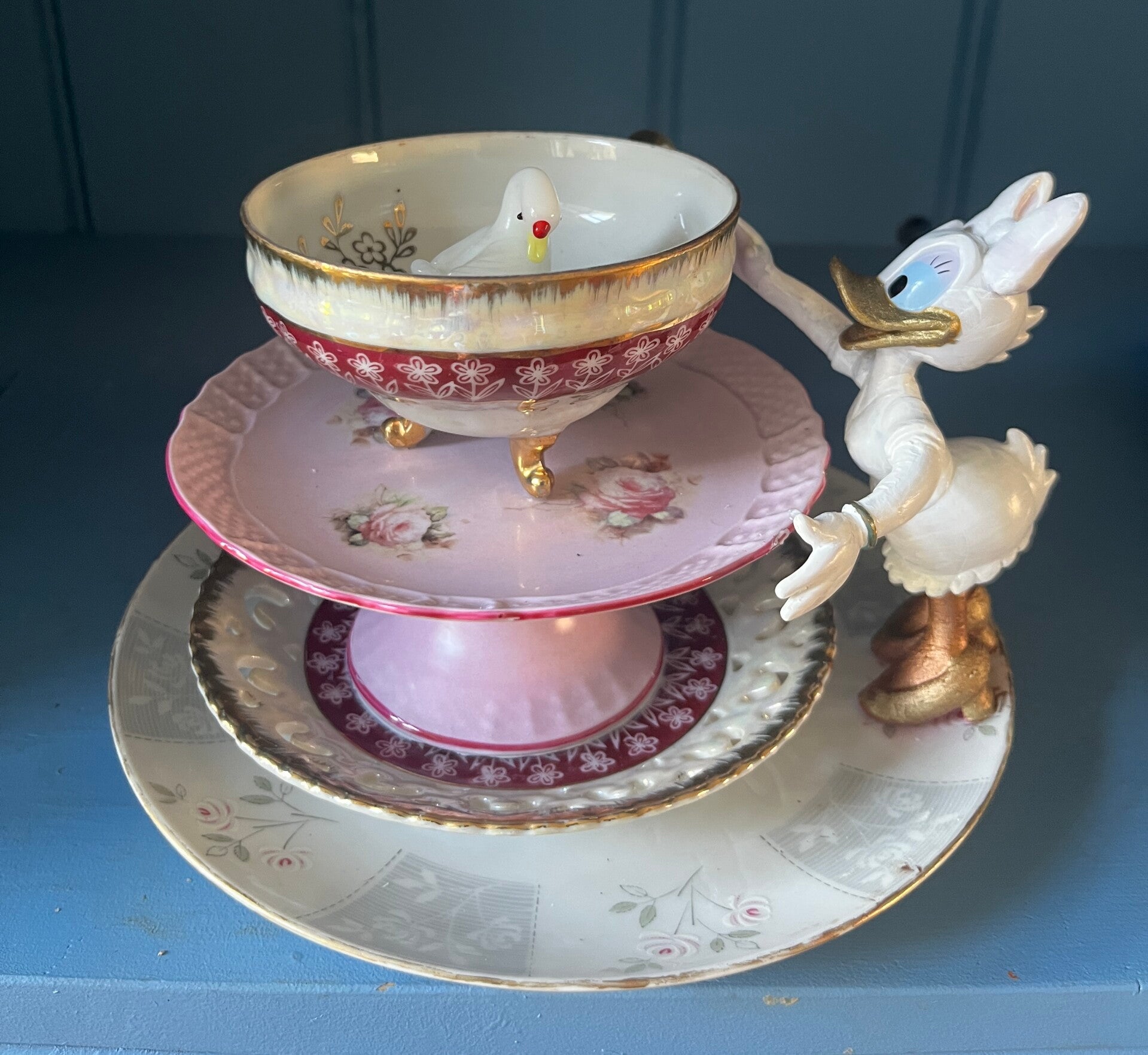 A Curious Encounter, a one-of-a-kind WonderLust Object by Dutch artist Margreet Blaas. A vintage porcelain bowl with a small white bird is watched by a curious duck character, creating a playful porcelain assemblage inspired by wonder and storytelling