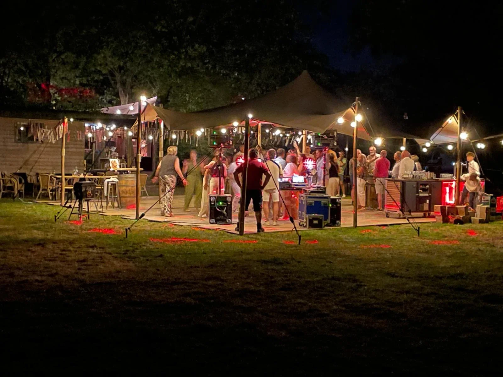 Feestgasten onder een verlichte stretchtent tijdens het tuinfeest van Ron en Anja, foto van Ronny Derks