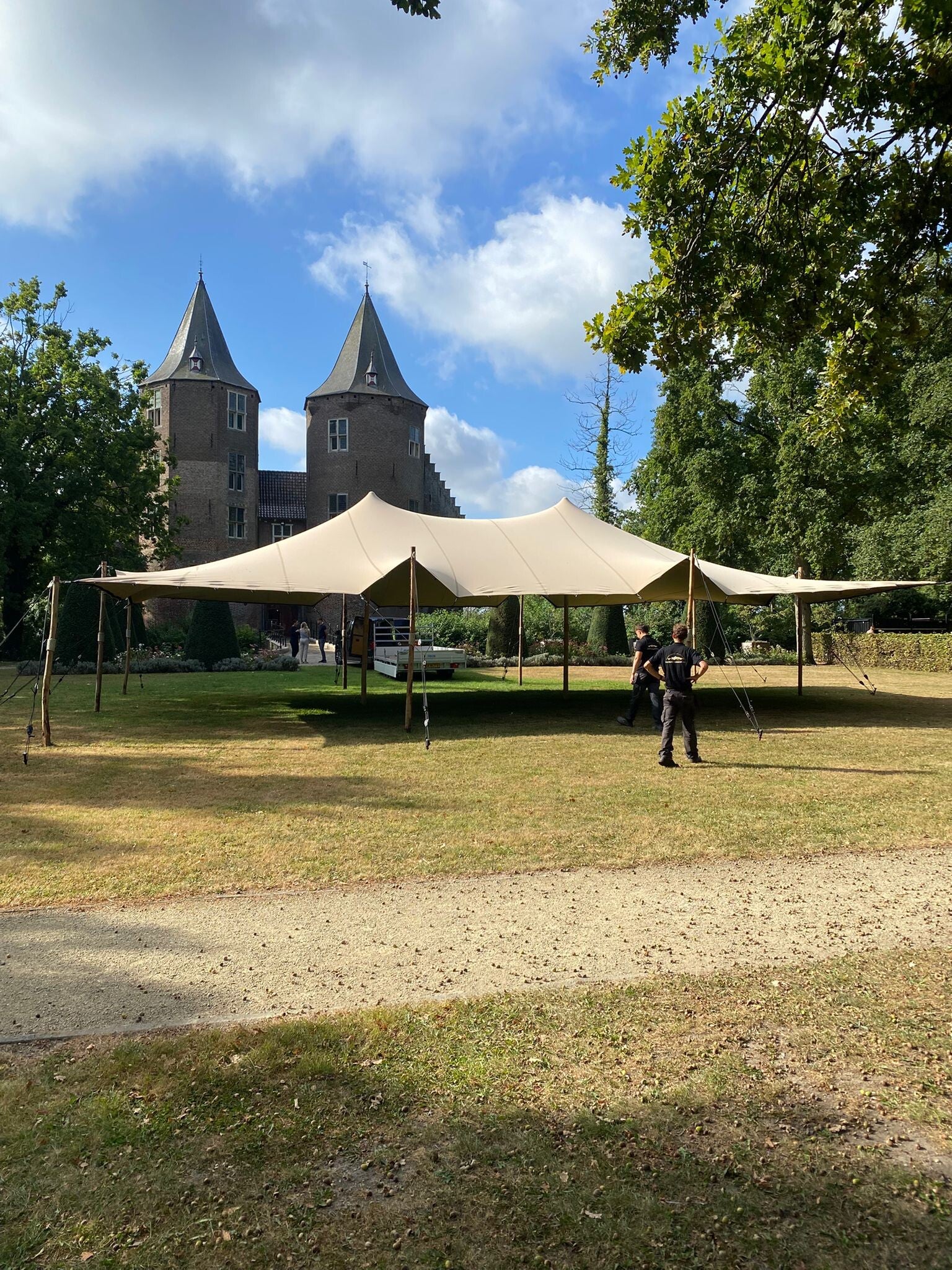 Medewerkers van Tentjevoordesfeer bij een zandkleurige stretchtent op een kasteellocatie