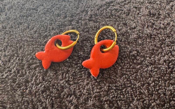 Boucles d’oreilles poisson marron foncé.