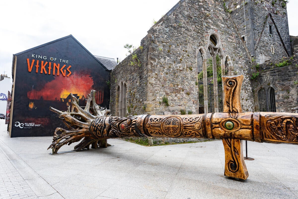 A photo of a square in waterford city, a wall painted with a Viking fight.