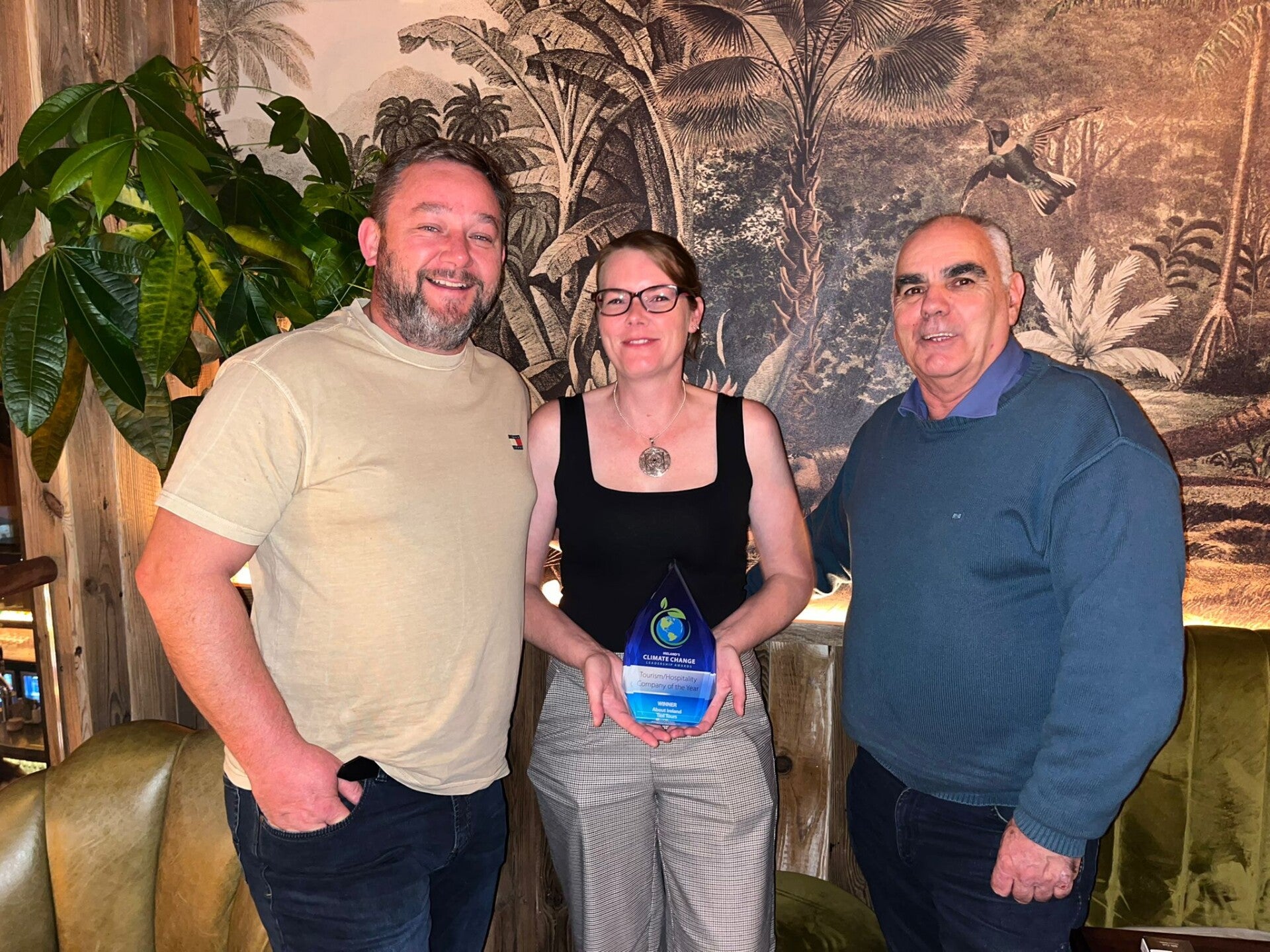 Keith (l), Jenny (m) and Bob (r) posing for a photo holding the award. 