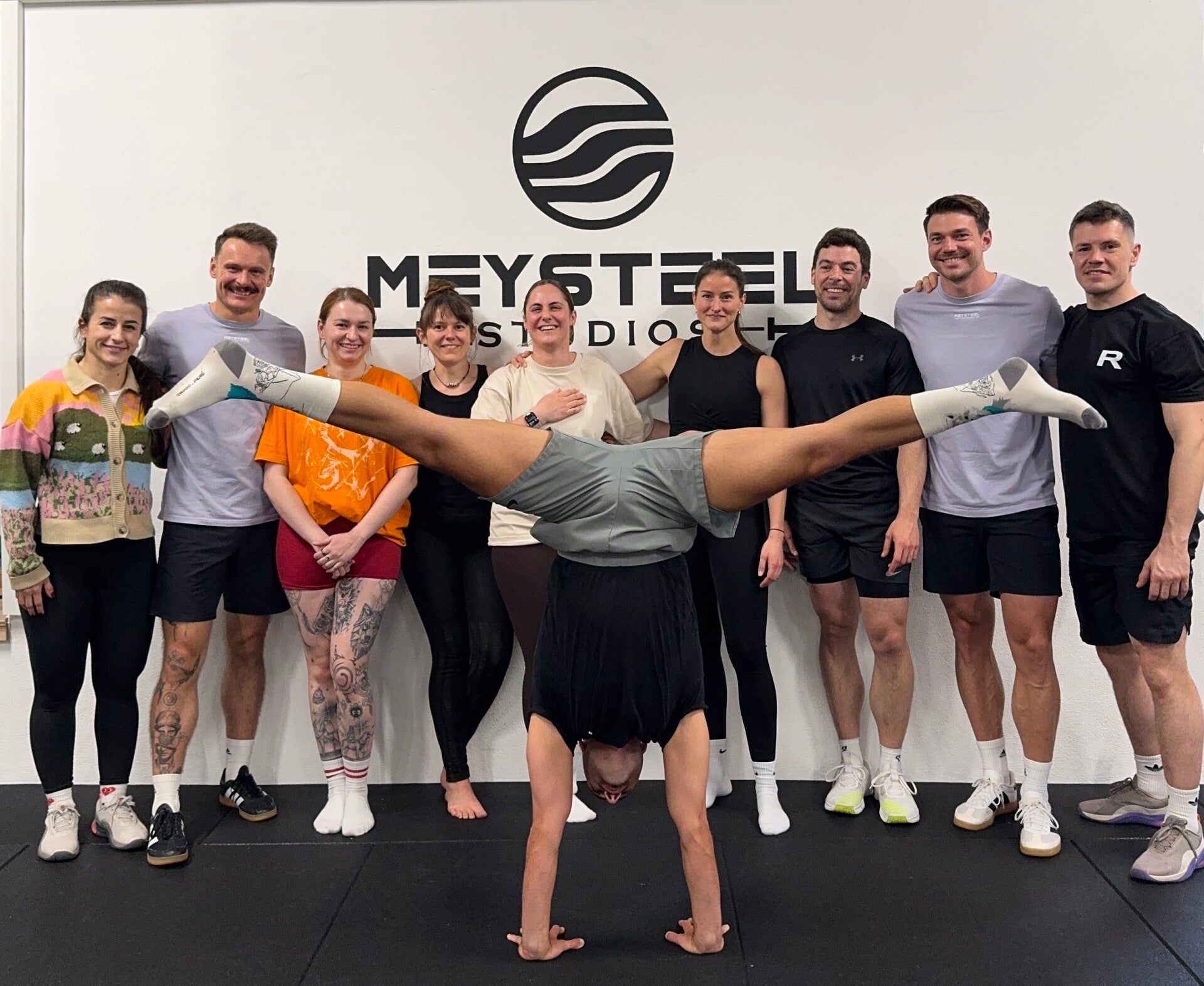 Dario Lo Voi im Handstand mit einer Workshopgruppe