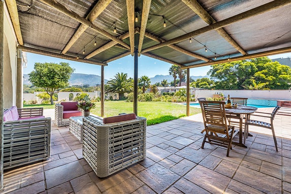 Outdoor terrace with lounge seating overlooking Constantia wine farms