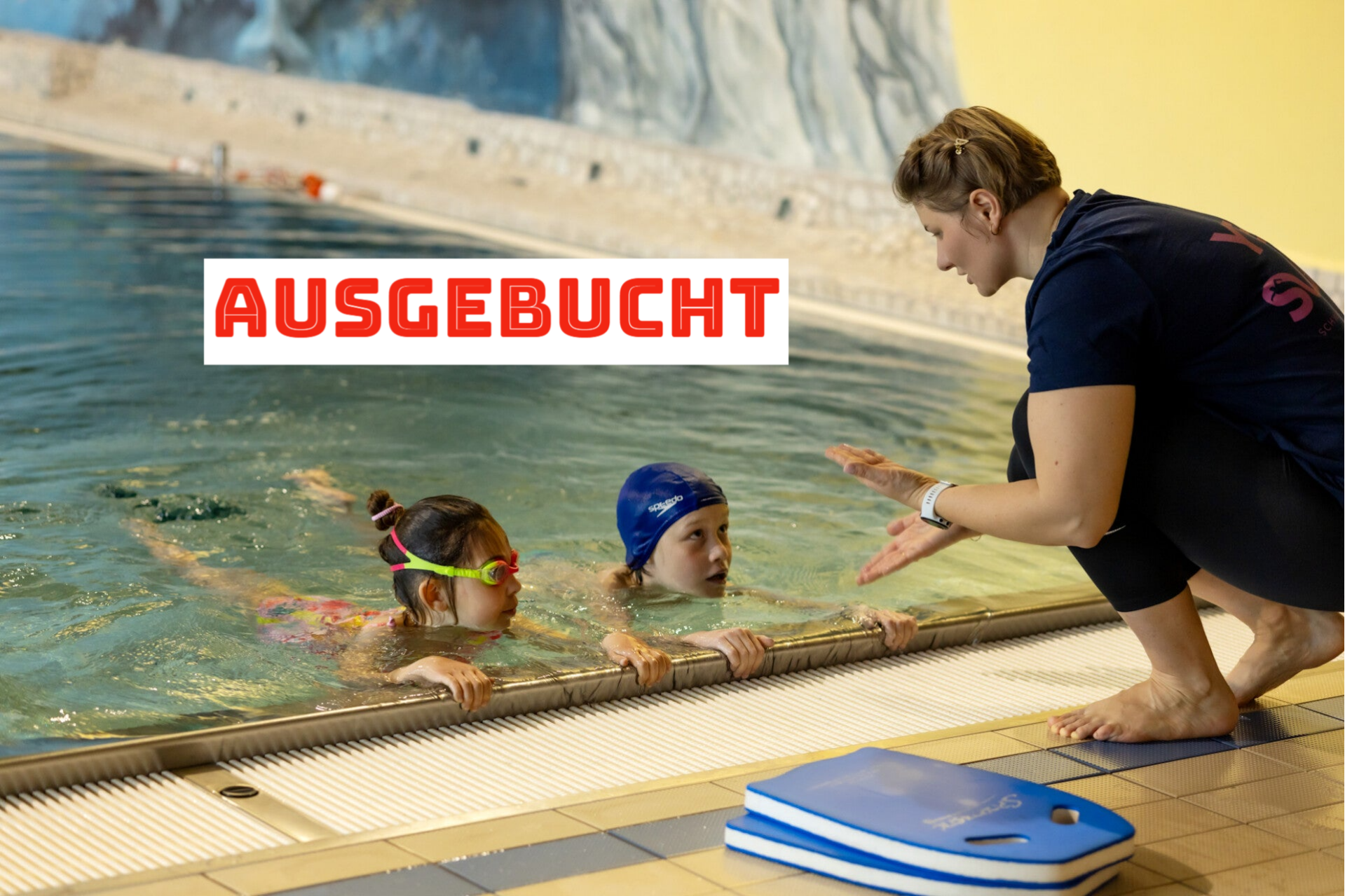 Schwimmlehrerin von yes.swim Schule erklärt den Kindern, wie man die Beine bewegen soll