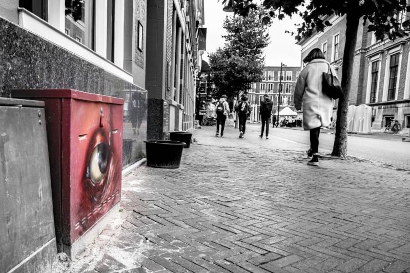 Street art rood oog volgt een vrouw