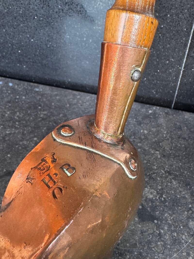 Close-up of antique copper scoop handle  stamped marks
