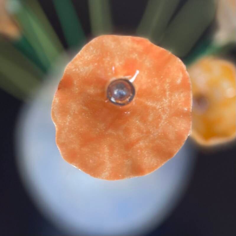 Oranje keramieken bloem met gouden kern