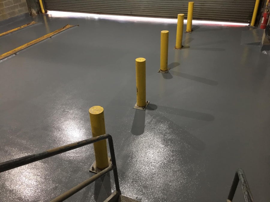 Durable resin floor in a warehouse with safety bollards