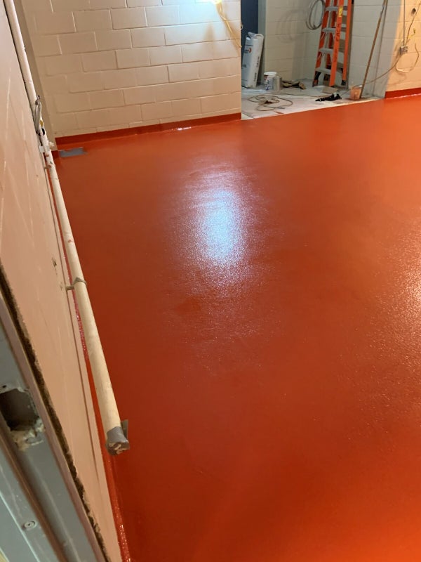 Red solid-color epoxy floor with cove base by ProResin Flooring Solutions