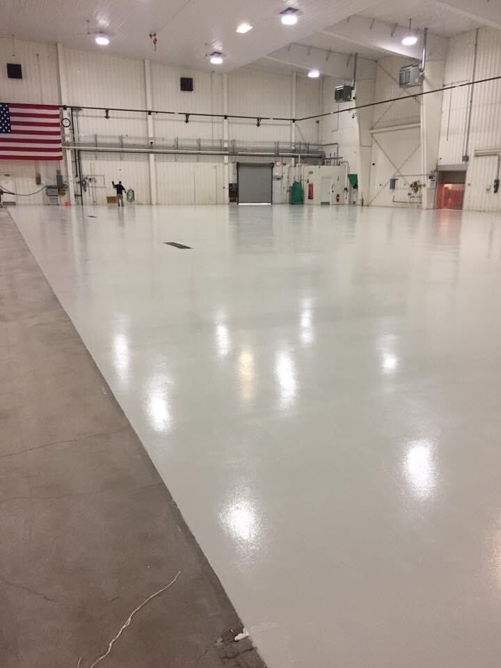 High-gloss epoxy floor in a large commercial hangar