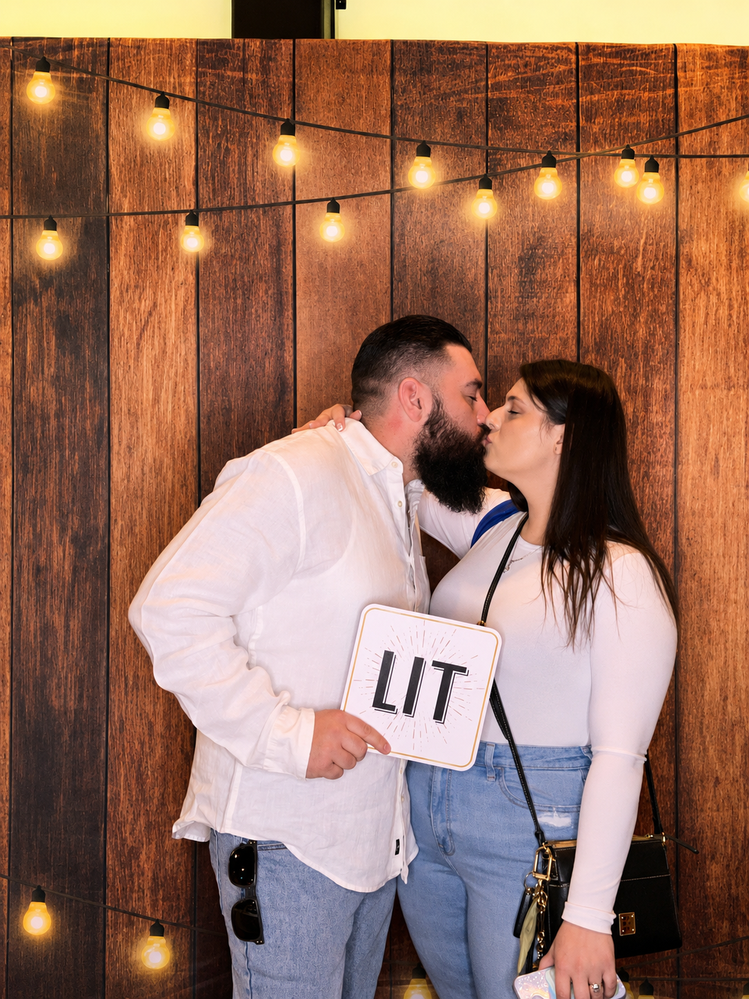 Bride and groom celebrating with family and friends at a luxury wedding photo booth reception.