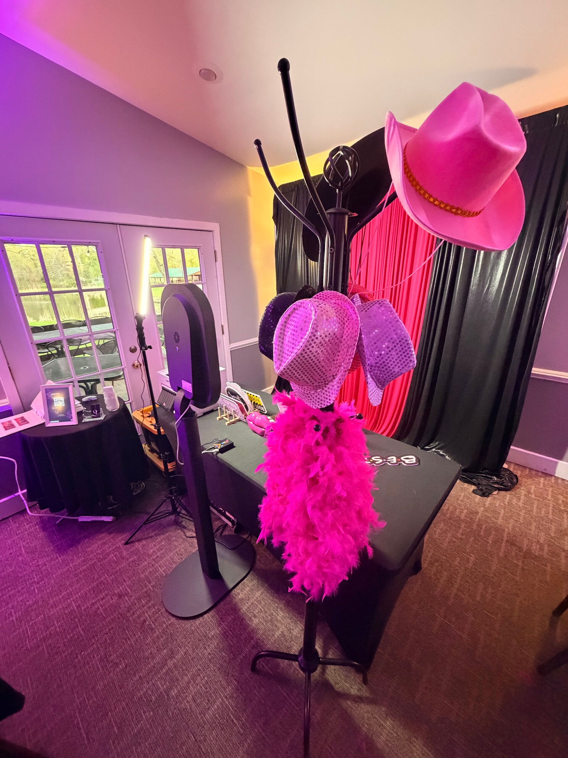 Modern party photo booth setup with pink backdrop and props
