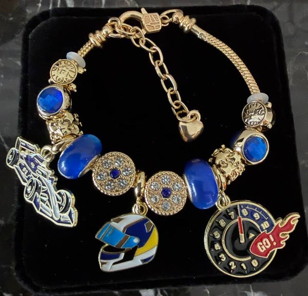 Jewelry -The Gold Tone Race Car Charm Bracelet Helmet Clock Charms in Blue and Gold