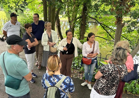 Group gathering around the tour Guide in St Stephen's Green by the lake