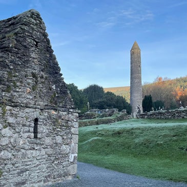 Early Christian church ruin with Round Tower in the background at Glendalough