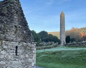 view of the round tower at Glendalough with St Kevin's Church partly in the foreground
