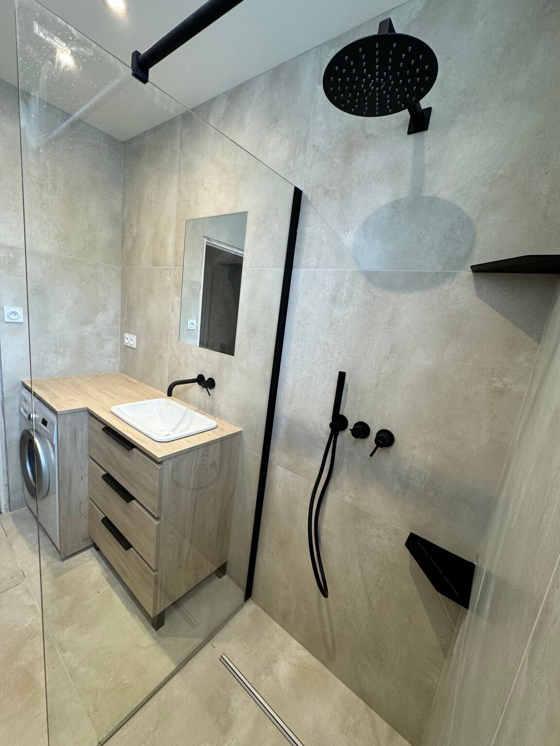 Salle de bain rénovée au Grau-du-Roi, résidence Le Priska : douche vitrée et robinetterie noire