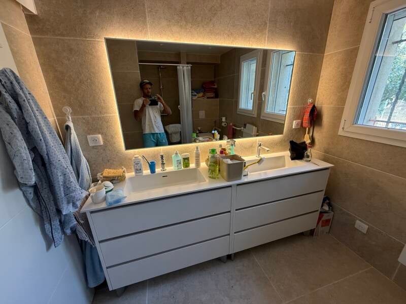 Salle de bain aménagée : double vasque et grand miroir lumineux