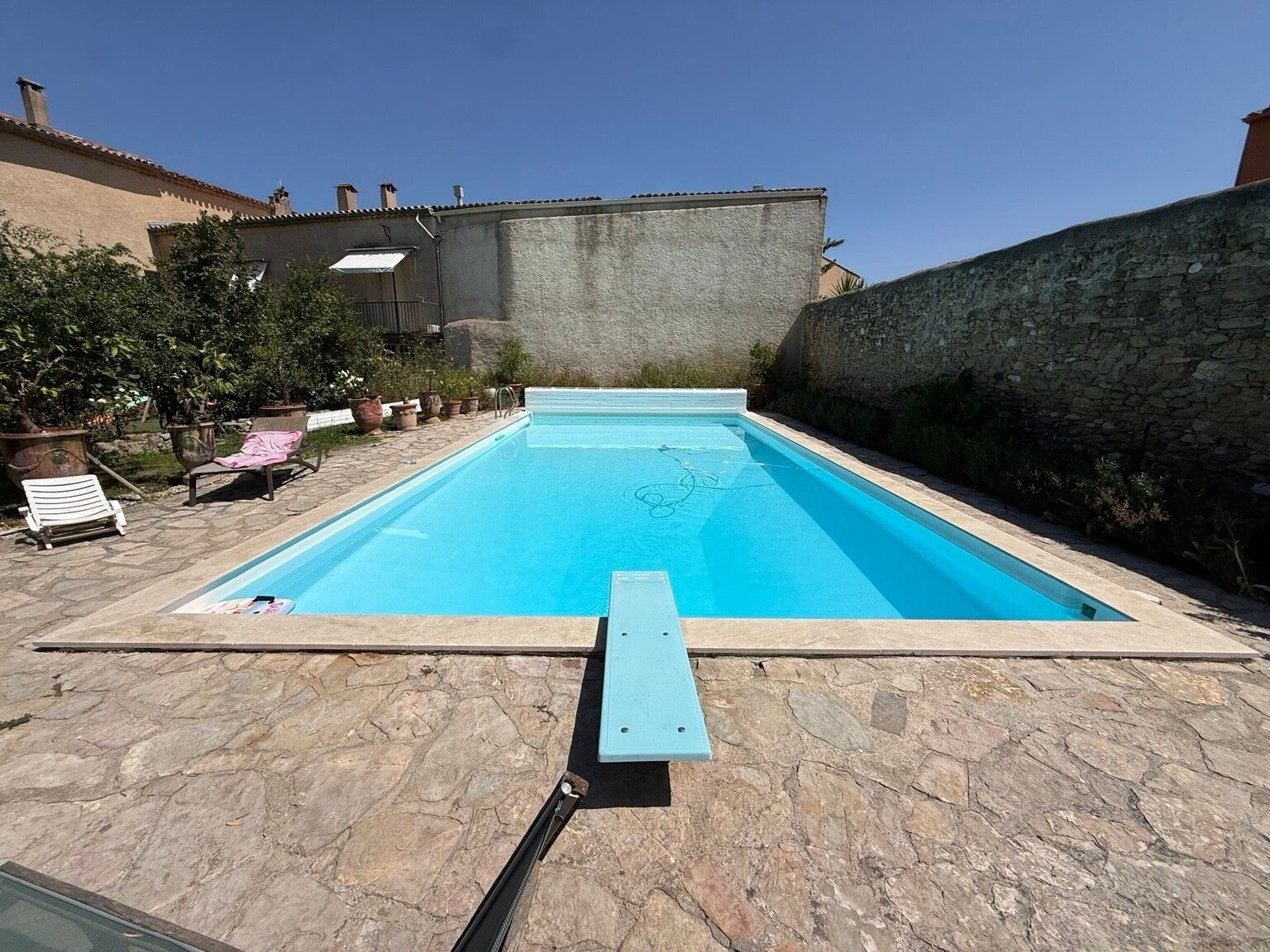 Piscine de 6 × 12 m rénovée à Gignac par LETUFF, margelles en travertin et finition gelcoat