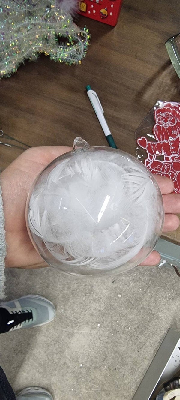 Transparente Weihnachtskugel mit weissen Federn