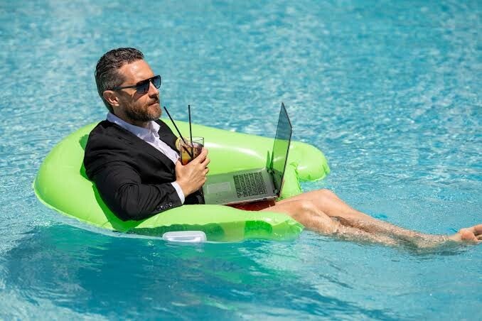 Man met een laptop kijkt tijdens de vakantie naar buiten