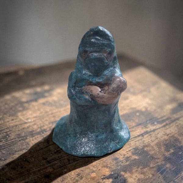 Handgemaakt beeldje van klei  moslima met kind