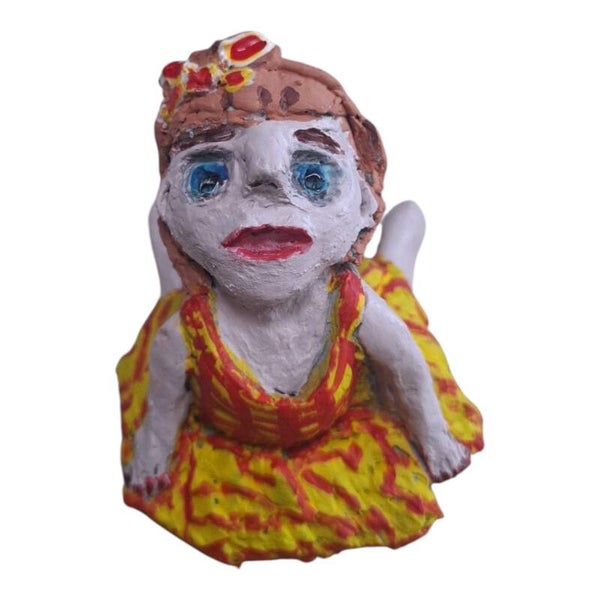 Handgemaakt beeldje van klei blij kind