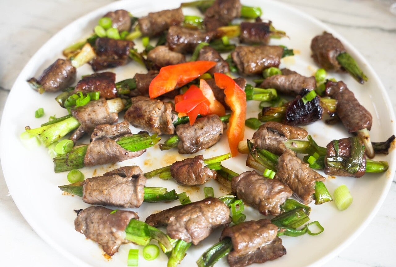 personal chef services cooks beef negimaki topped with  red peppers