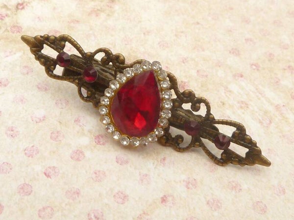 Funkelnder Haarclip mit facettiertem Glascabochon in rot klarer Strass