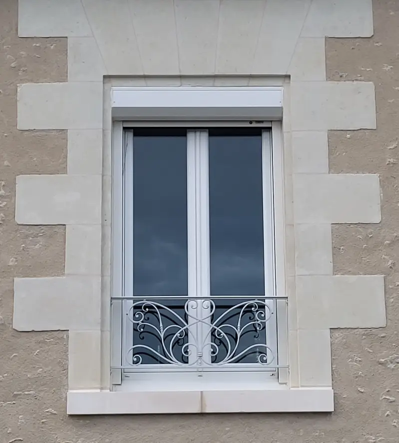Garde-corps de fenêtre en fer forgé blanc, motif à grandes volutes façonné dans l’esprit de la ferronnerie traditionnelle