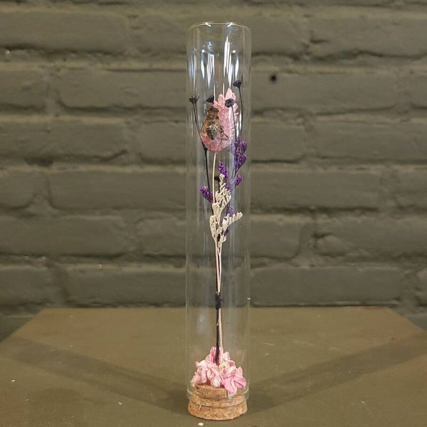 Stolp met droogbloemen en bij