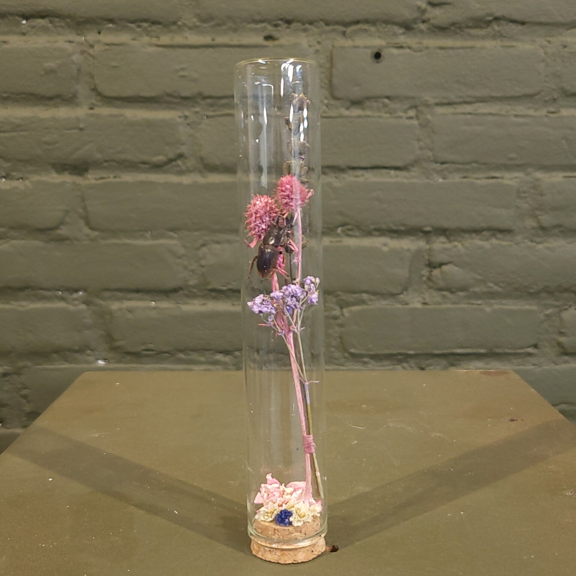 Stolp met droogbloemen en kever