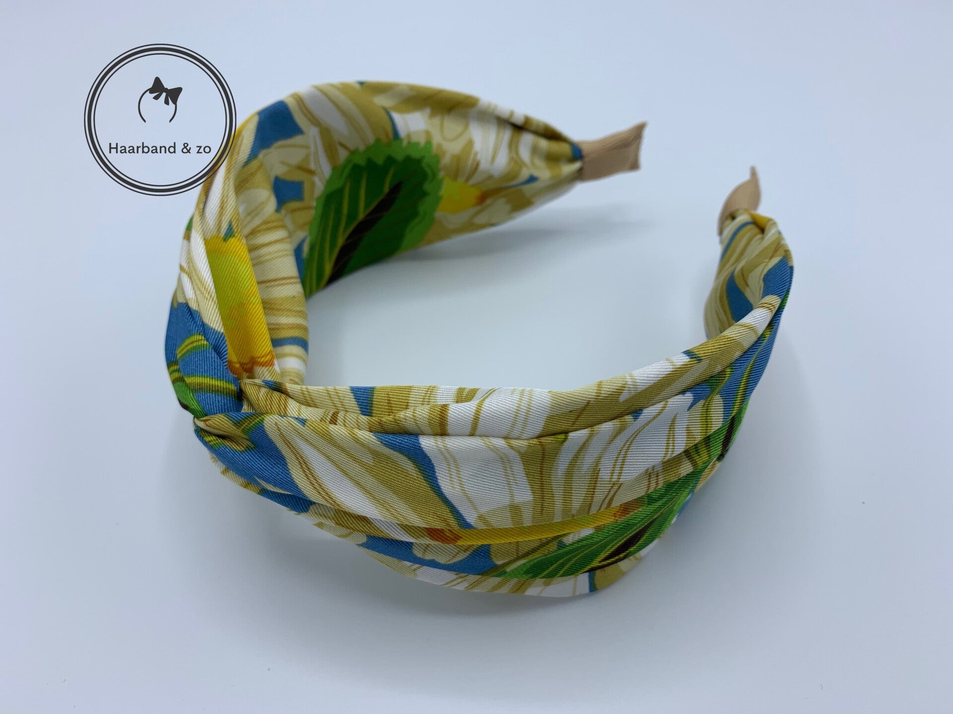 Brede booghaarband met twist in bloemenprint, hoofdkleur blauw (art.nr. 123-12)